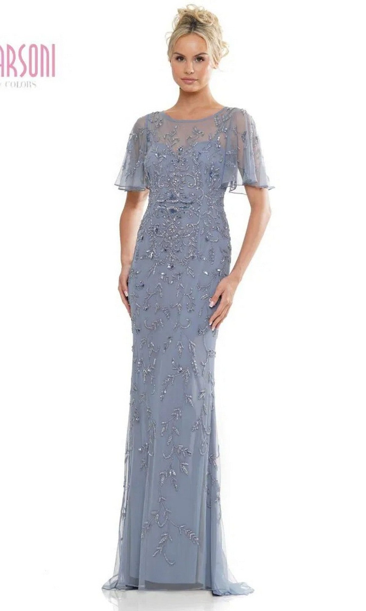 A woman wears the Marsoni MV1281 long formal dress in slate blue, featuring short sheer sleeves, an illusion sweetheart neckline, and intricate beadwork on the bodice and skirt.